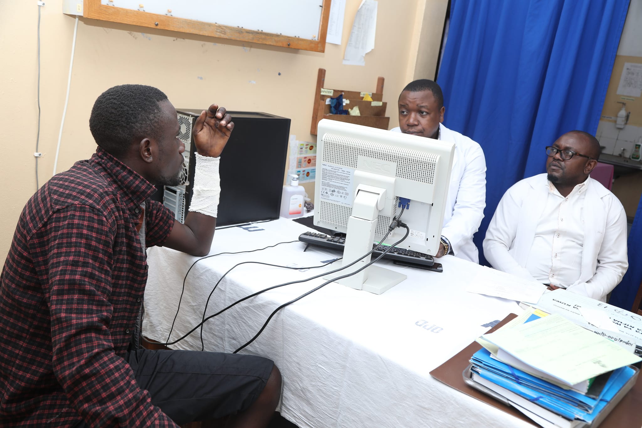 Patient consulting two clinicians in an outpatient room